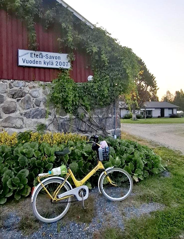 Keltainen pyörä parkkeerattuna vanhan kivinavetan eteen.