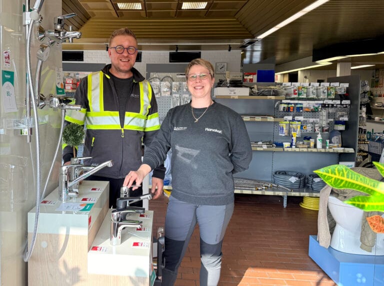 Kaksi ihmistä esittelevät vesihanaa LVI-myymälässä.