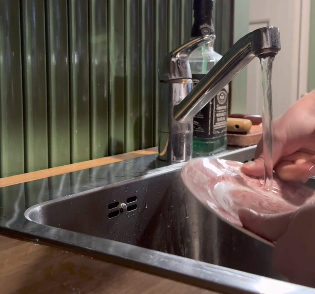 Lähikuva astioita tiskaavista käsistä.