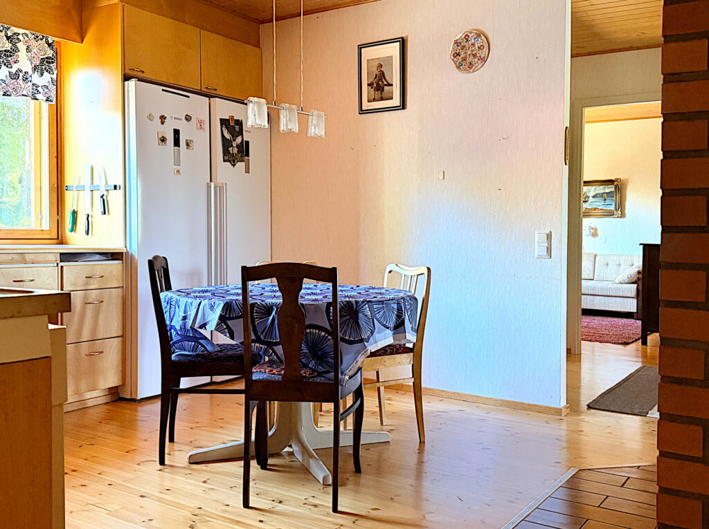 Pyöreä ruokailuryhmä, jonka takana valkoiset jääkaapit.